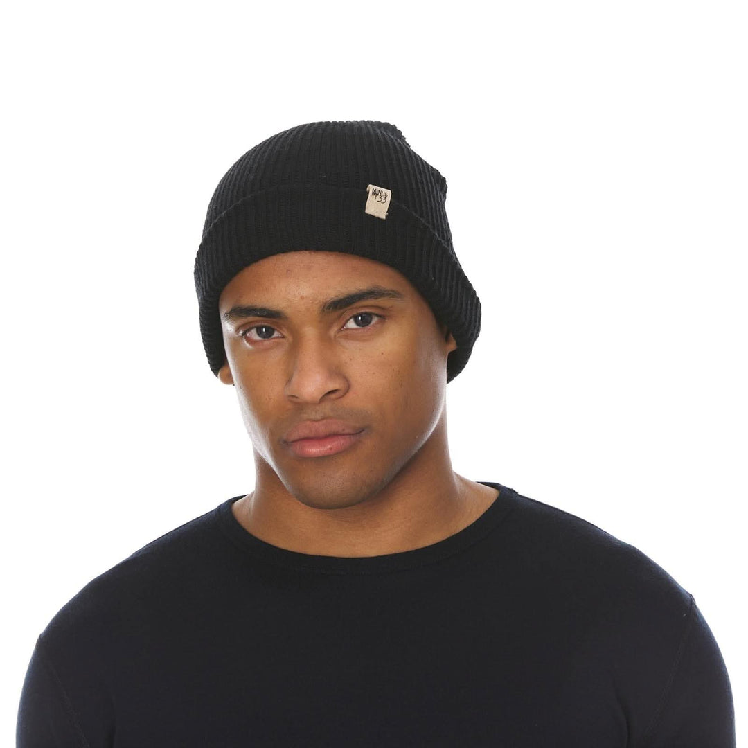 A man models the midweight hundred percent merino wool beanie 