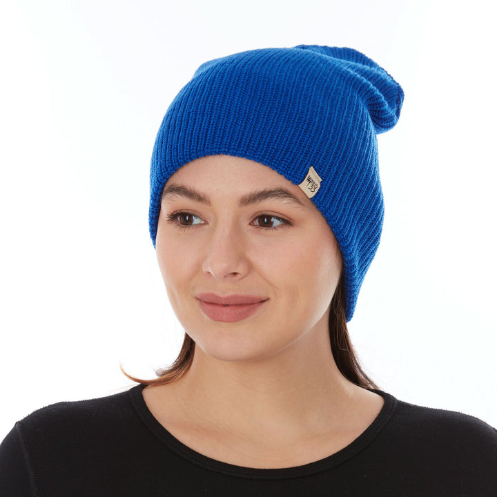 Head-and-shoulders front view of a female model wearing a royal blue midweight 100% merino wool beanie with a folded cuff 