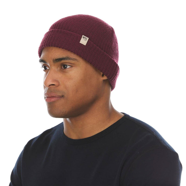 A man models the midweight hundred percent merino wool beanie 