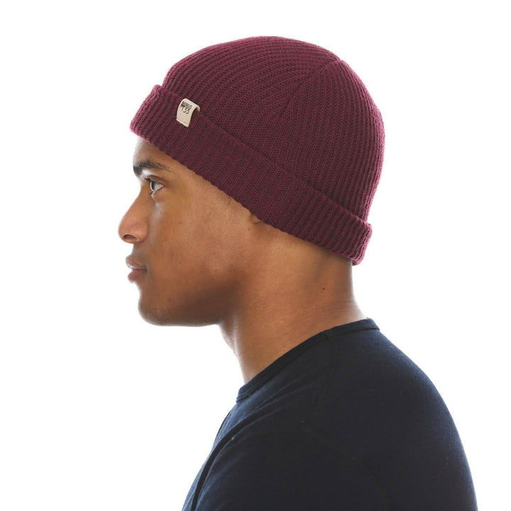 A man models the midweight hundred percent merino wool beanie, right-facing side view 