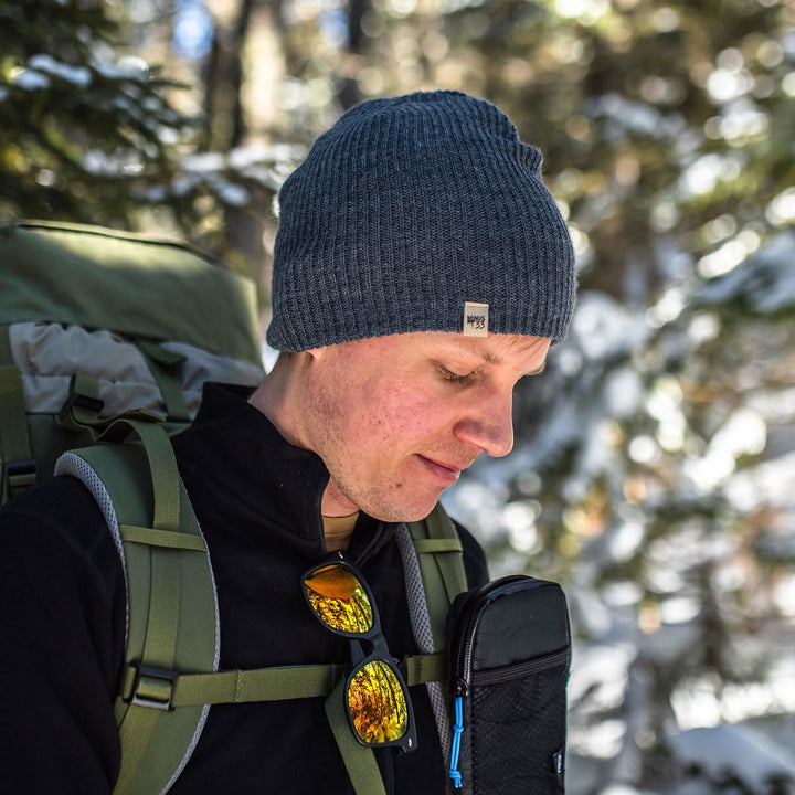 A man models the midweight hundred percent merino wool beanie 