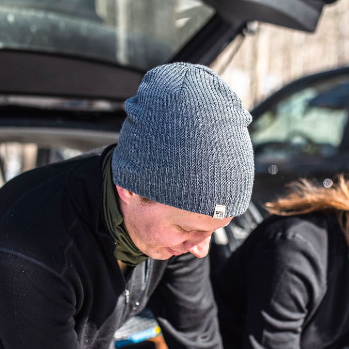 A man models the midweight hundred percent merino wool beanie 