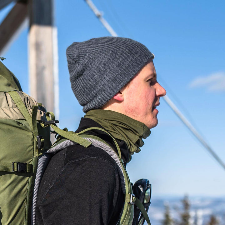 A man models the midweight hundred percent merino wool beanie 