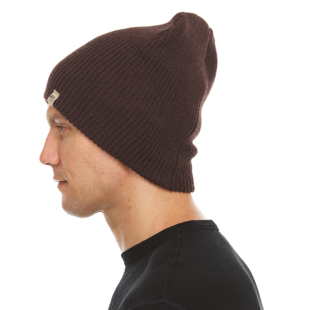 A man models the midweight hundred percent merino wool beanie 
