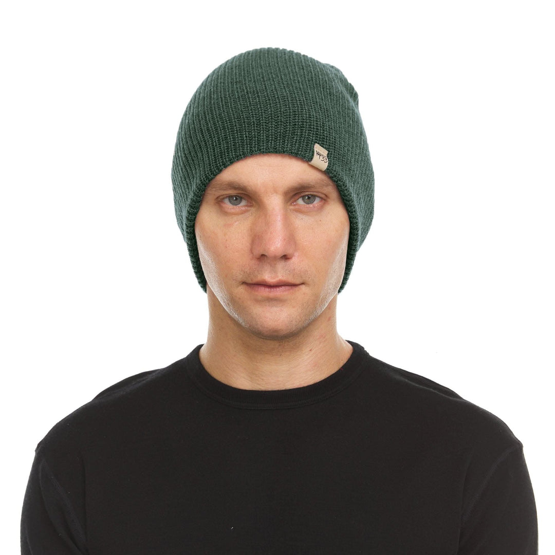 A man models the midweight hundred percent merino wool beanie 