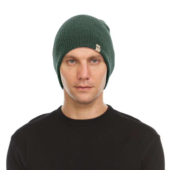 A man models the midweight hundred percent merino wool beanie 