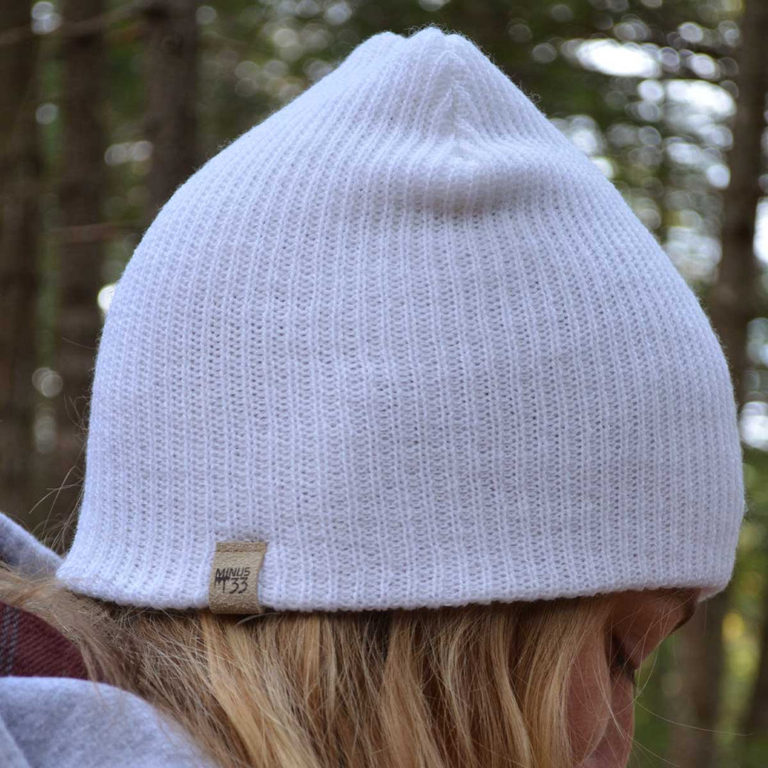 A woman models the midweight hundred percent merino wool beanie 