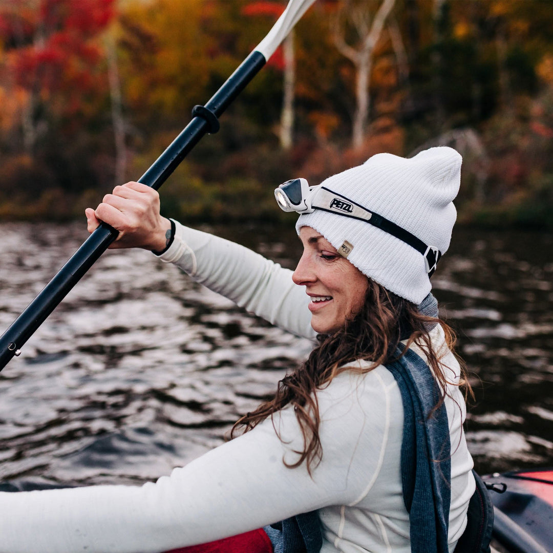 A woman kayaks in her midweight hundred percent merino wool beanie 