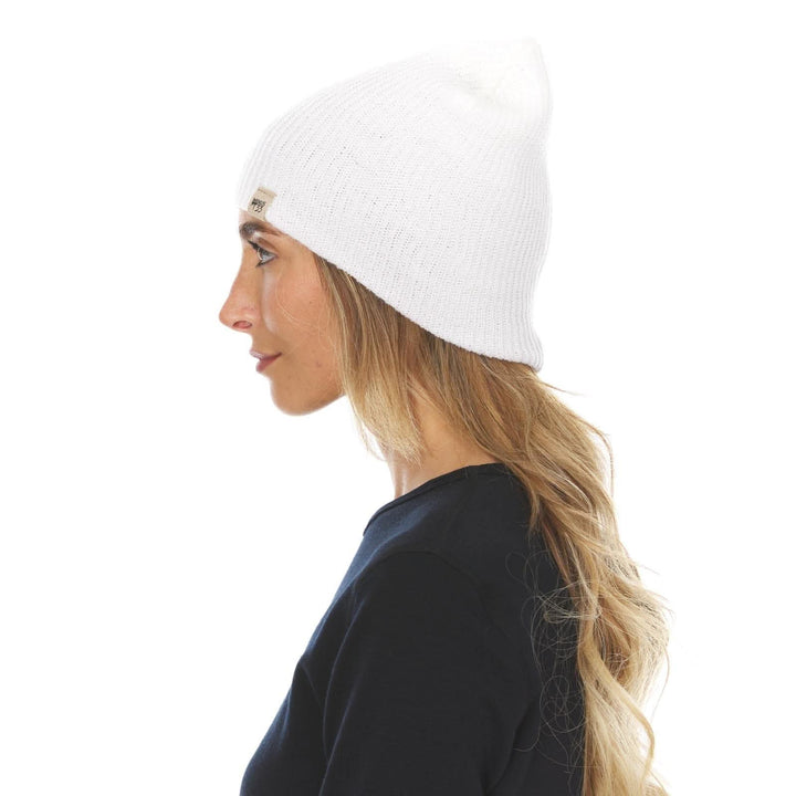A woman models the midweight hundred percent merino wool beanie 