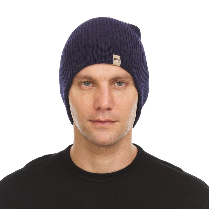 A man models the midweight hundred percent merino wool beanie 