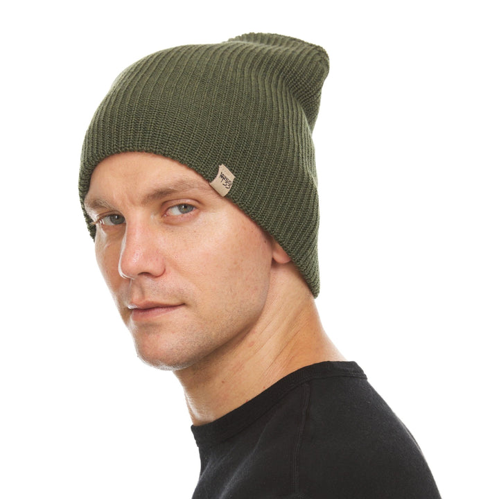 A man models the midweight hundred percent merino wool beanie 