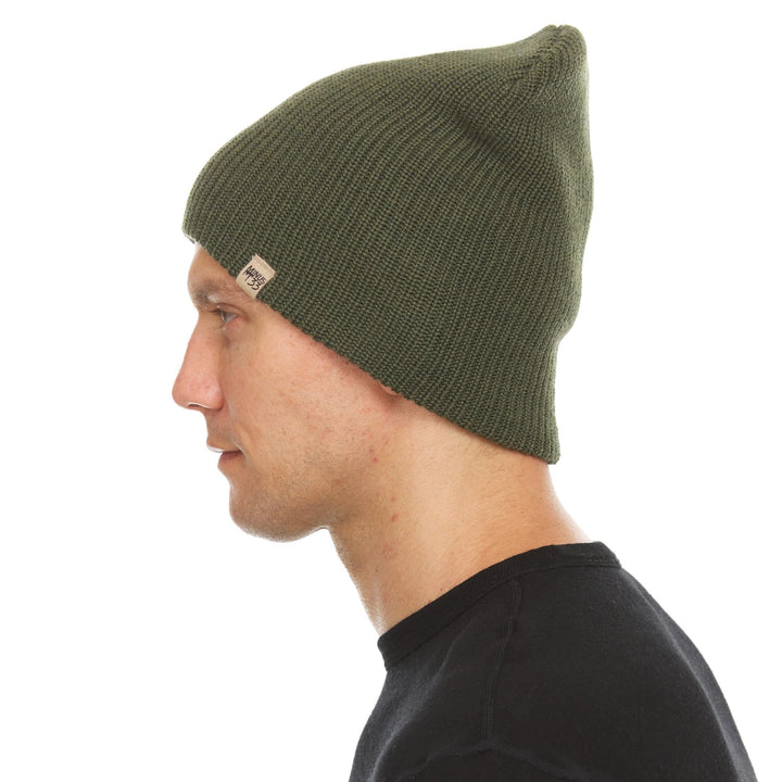 A man models the midweight hundred percent merino wool beanie 