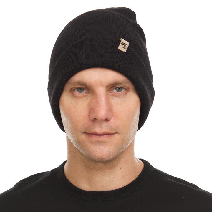 A man models the midweight double-layered merino wool beanie, front three-quarter view 
