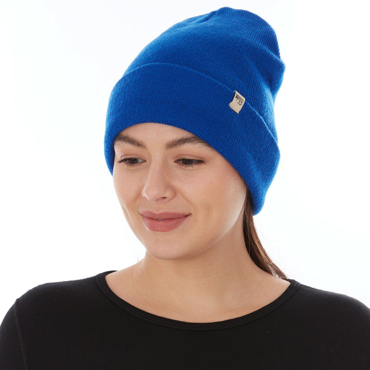 A woman models the midweight, double-layered, hundred percent, super soft merino wool beanie that keeps you warm, but won&