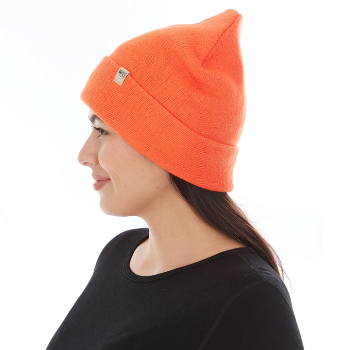 A woman models the midweight, double-layered, hundred percent, super soft merino wool beanie that keeps you warm, but won&