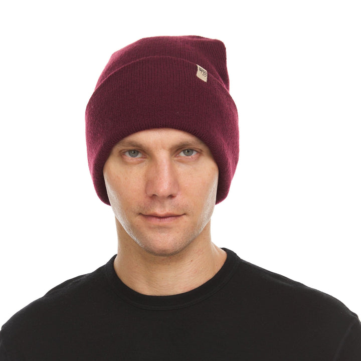 A man models the midweight, double-layered, hundred percent, super soft merino wool beanie that keeps you warm, but won&