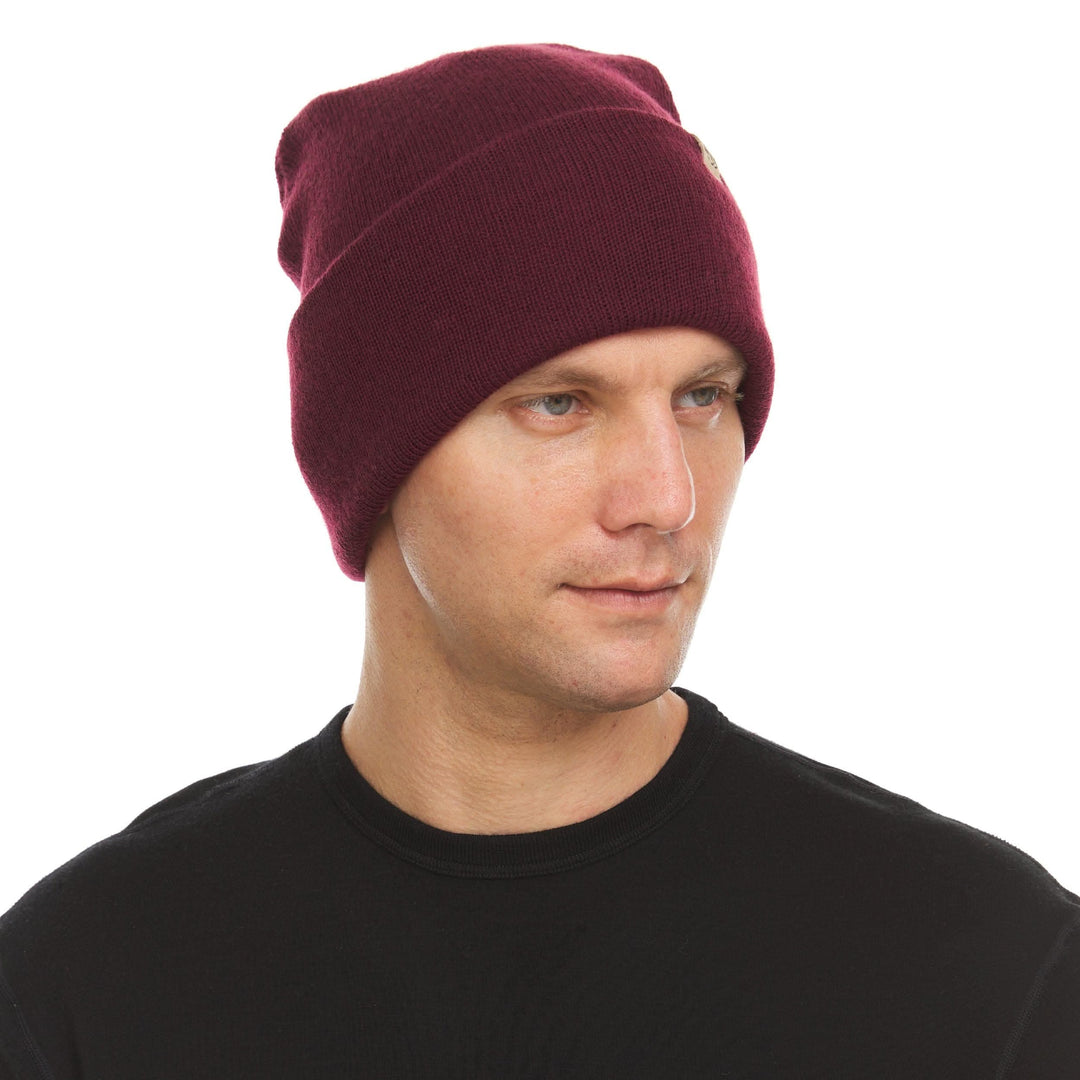 A man models the midweight, double-layered, hundred percent, super soft merino wool beanie that keeps you warm, but won&