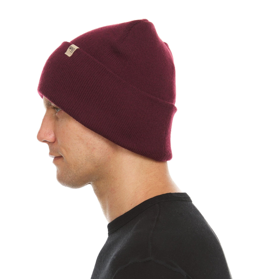 A man models the midweight, double-layered, hundred percent, super soft merino wool beanie that keeps you warm, but won&
