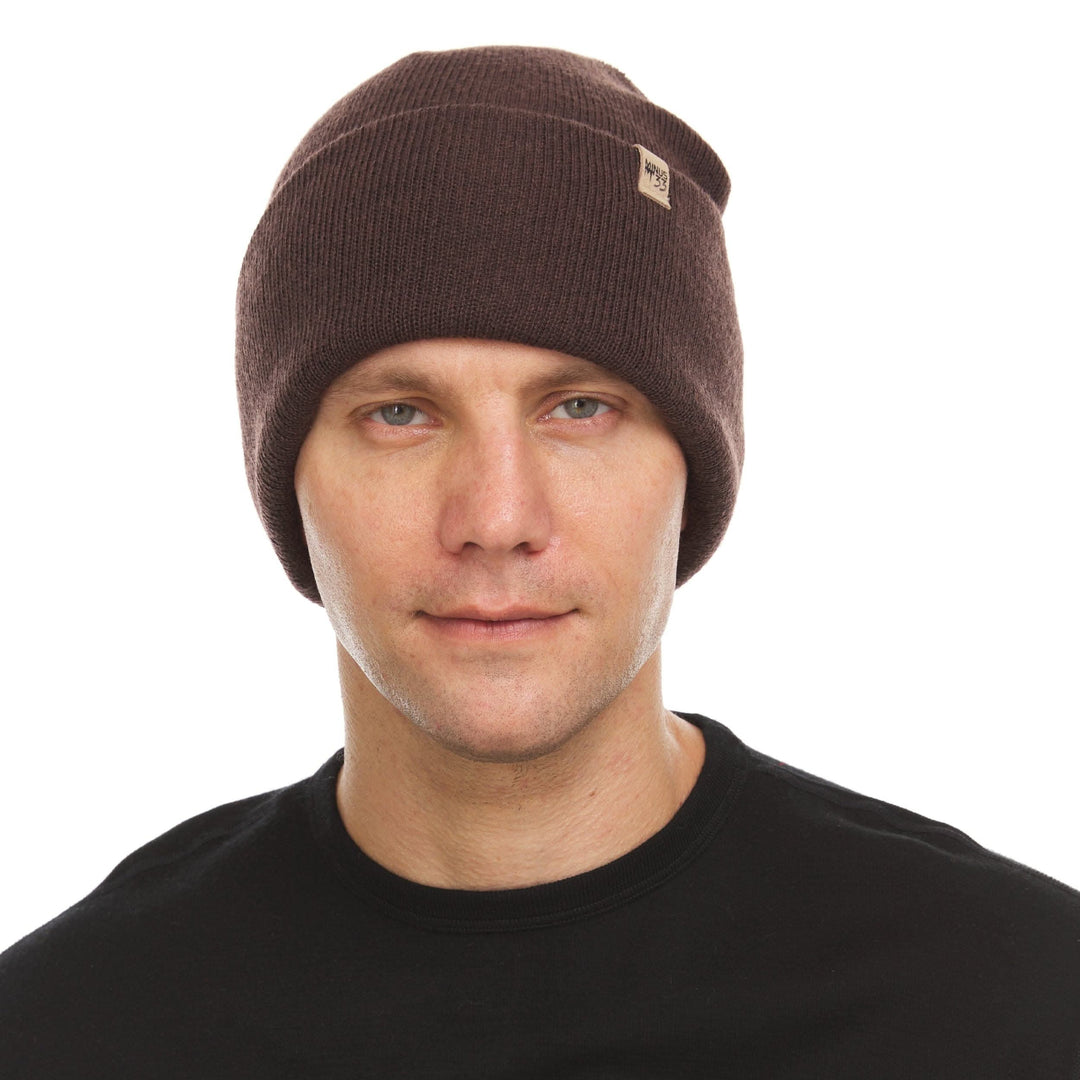 A man models the midweight, double-layered, hundred percent, super soft merino wool beanie that keeps you warm, but won&