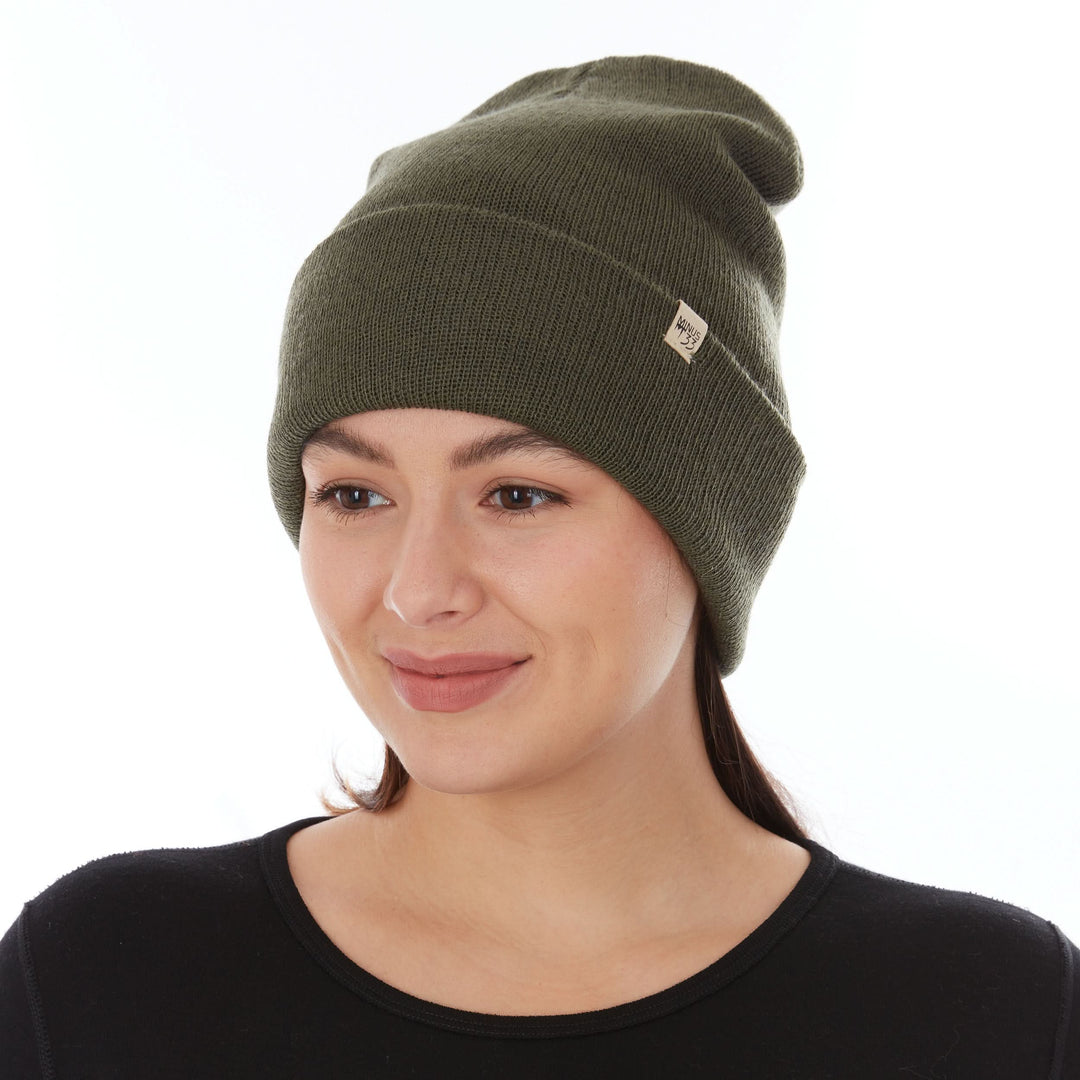 A woman models the midweight, double-layered, hundred percent, super soft merino wool beanie that keeps you warm, but won&
