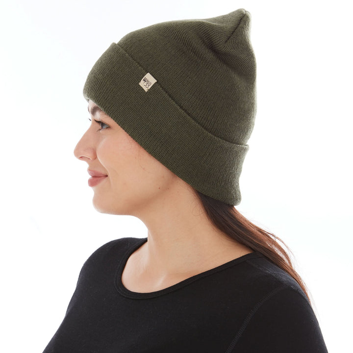 Side profile view of a female model wearing an olive drab green midweight double-layer 100% merino wool beanie 