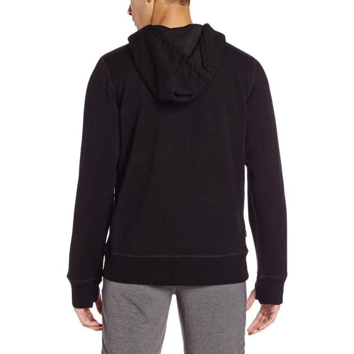 A man models the heavyweight brushed wool Kodiak Fleece Hoodie, crafted with thumbholes and a drawstring to bundle you up for wicked cold days! 