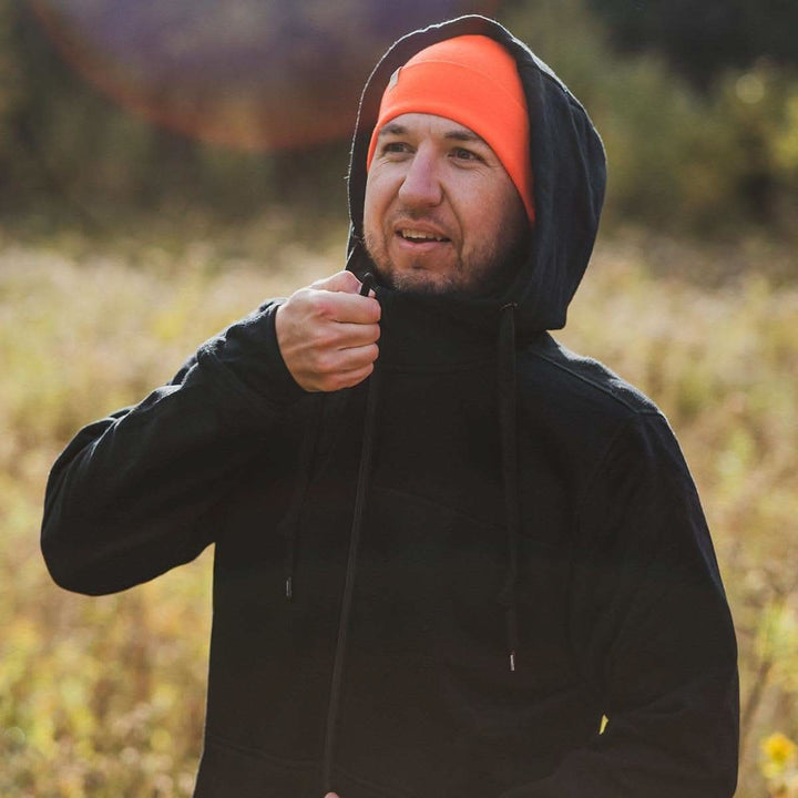 A man zips up his heavyweight brushed wool Kodiak Fleece Hoodie, crafted with thumbholes and a drawstring to bundle you up for wicked cold days! 