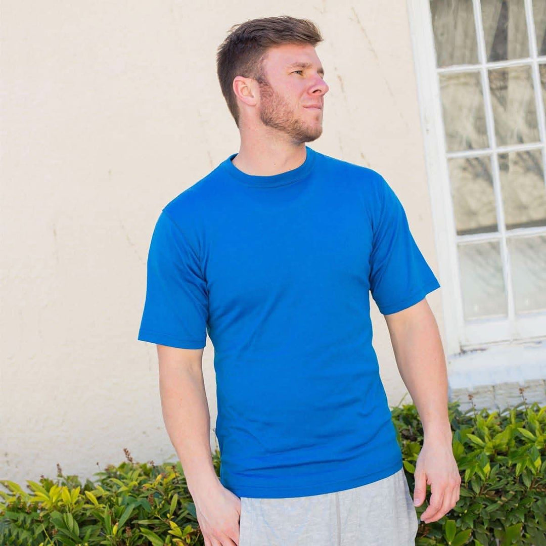 A man models a super soft, short sleeved merino wool t shirt. Use it as a base layer under your work shirt, or wear it all by itself during your next summer summit, front three-quarter view outdoors 