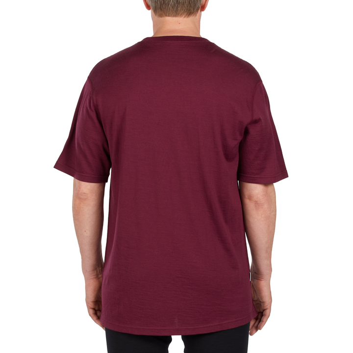 A man models a super soft, short sleeved merino wool t shirt. Use it as a base layer under your work shirt, or wear it all by itself during your next summer summit, back view 
