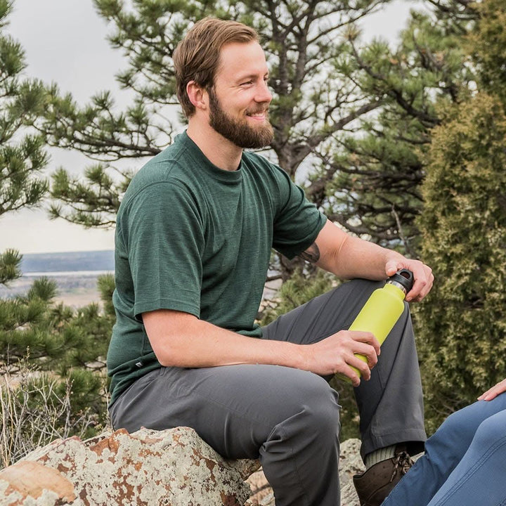 A man models a super soft, short sleeved merino wool t shirt. Use it as a base layer under your work shirt, or wear it all by itself during your next summer summit, front three-quarter view 