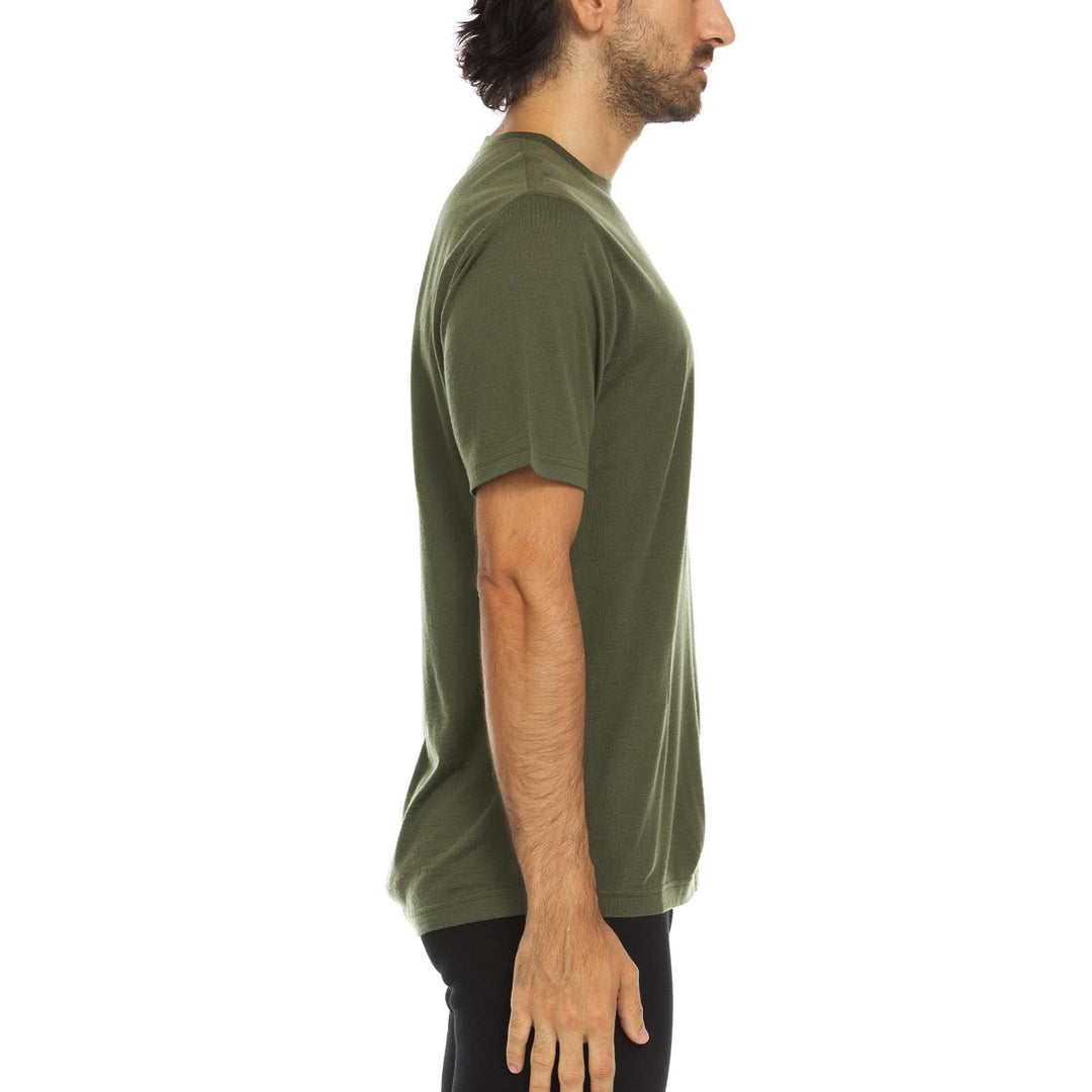 A man models a super soft, short sleeved merino wool t shirt. Use it as a base layer under your work shirt, or wear it all by itself during your next summer summit, right-facing side view 