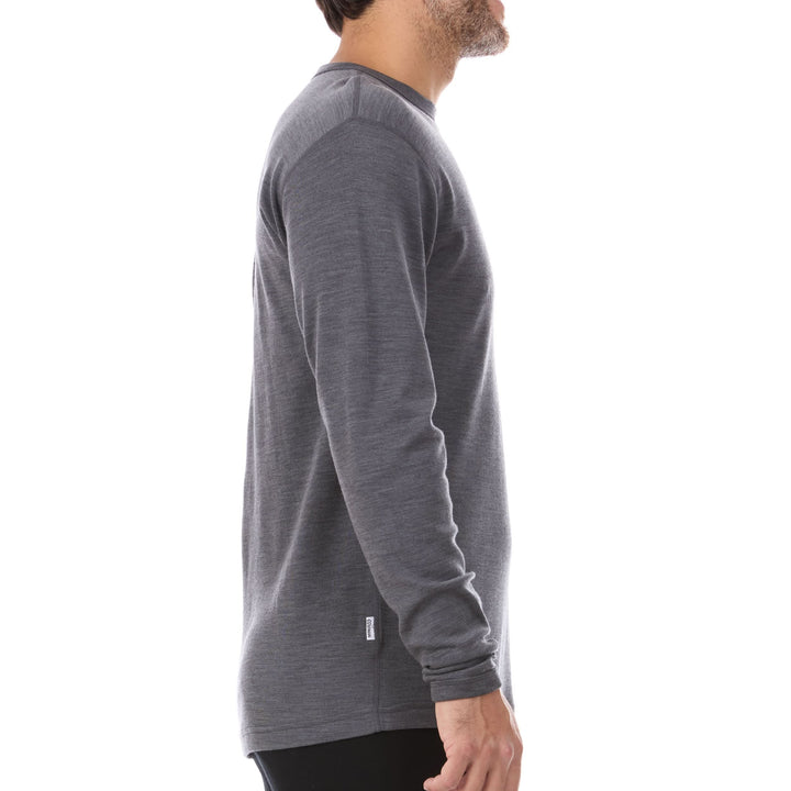 A man models a super soft, long sleeved merino wool thermal base layer crew. This top makes for a perfect first layer on a winter hike, or a nice casual wear on the chilly days of autumn and spring, side view 