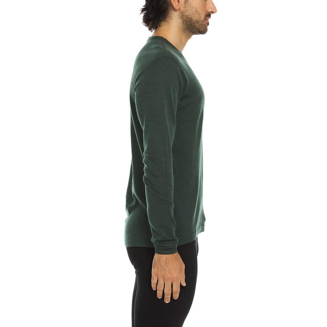 A man models a super soft, long sleeved merino wool thermal base layer crew. This top makes for a perfect first layer on a winter hike, or a nice casual wear on the chilly days of autumn and spring, right-facing side view 