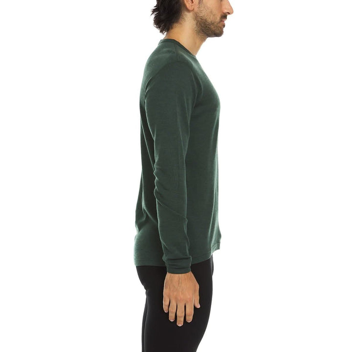 A man models a super soft, long sleeved merino wool thermal base layer crew. This top makes for a perfect first layer on a winter hike, or a nice casual wear on the chilly days of autumn and spring, right-facing side view 