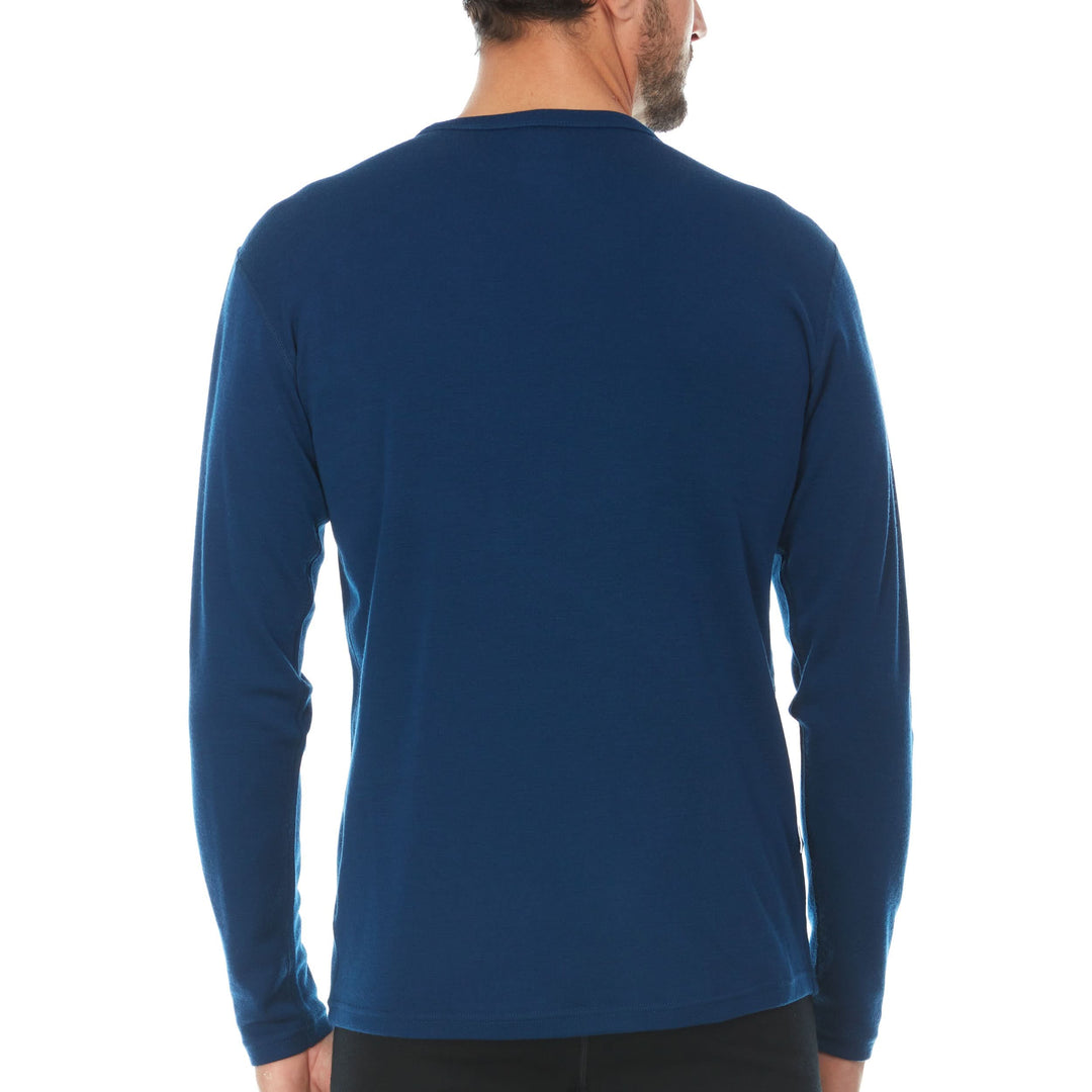 A man models a super soft, long sleeved merino wool thermal base layer crew. This top makes for a perfect first layer on a winter hike, or a nice casual wear on the chilly days of autumn and spring. 