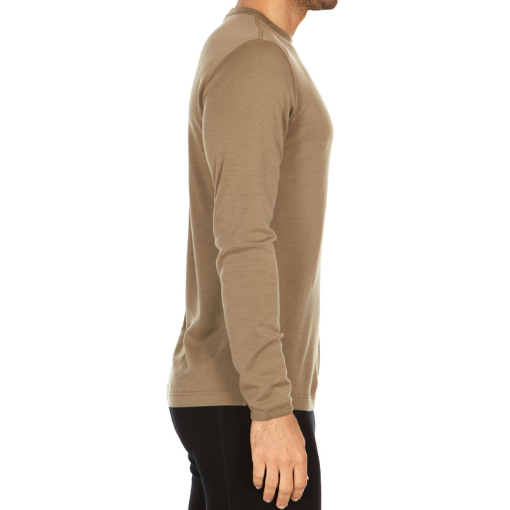 A man models a super soft, long sleeved merino wool thermal base layer crew. This top makes for a perfect first layer on a winter hike, or a nice casual wear on the chilly days of autumn and spring., right-facing side view 