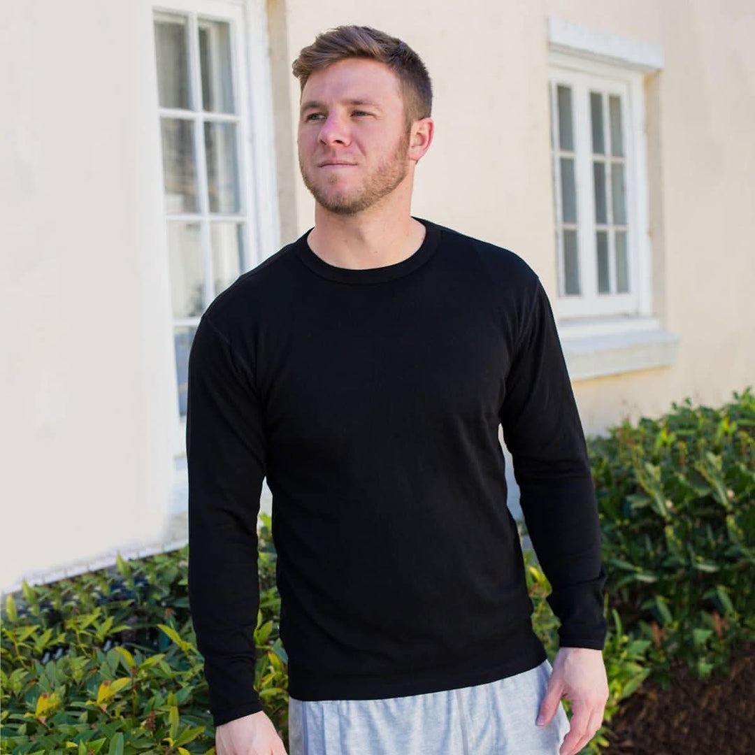 A man models a super soft, long sleeved merino wool thermal base layer crew. Whether you&