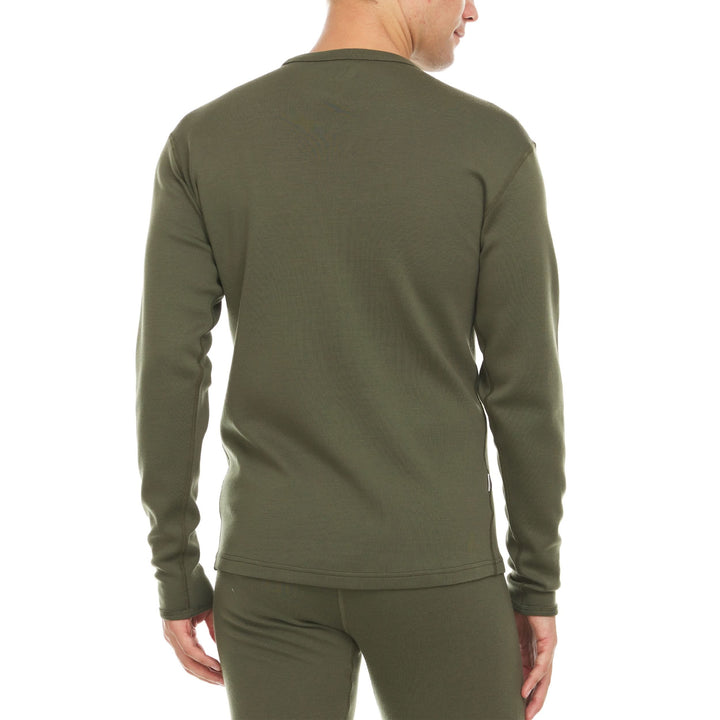 A man models a super soft, long sleeved merino wool thermal base layer crew. Whether you&