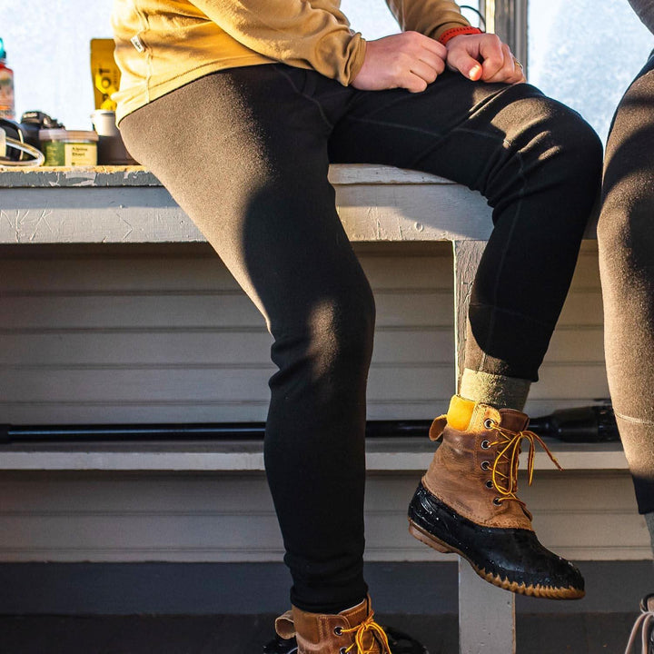 man sitting down wearing 100% merino wool expedition weight base layer black bottoms