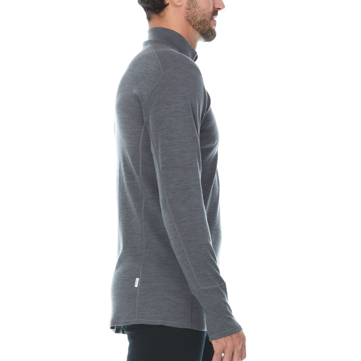 Side view of a man modeling the merino wool midweight quarter zip sweater in charcoal gray, complete with flat-lock seams and thumbholes. 