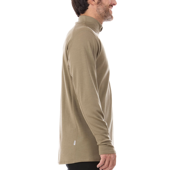 A man models the merino wool midweight quarter zip sweater, complete with flat-lock seams and thumbholes, side view 