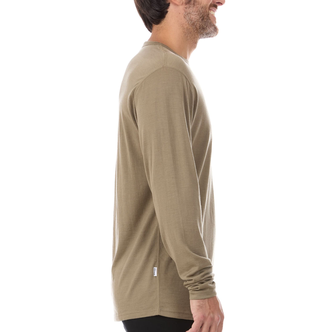 A man models the lightweight long sleeved merino wool base layer crew neck top, side view 