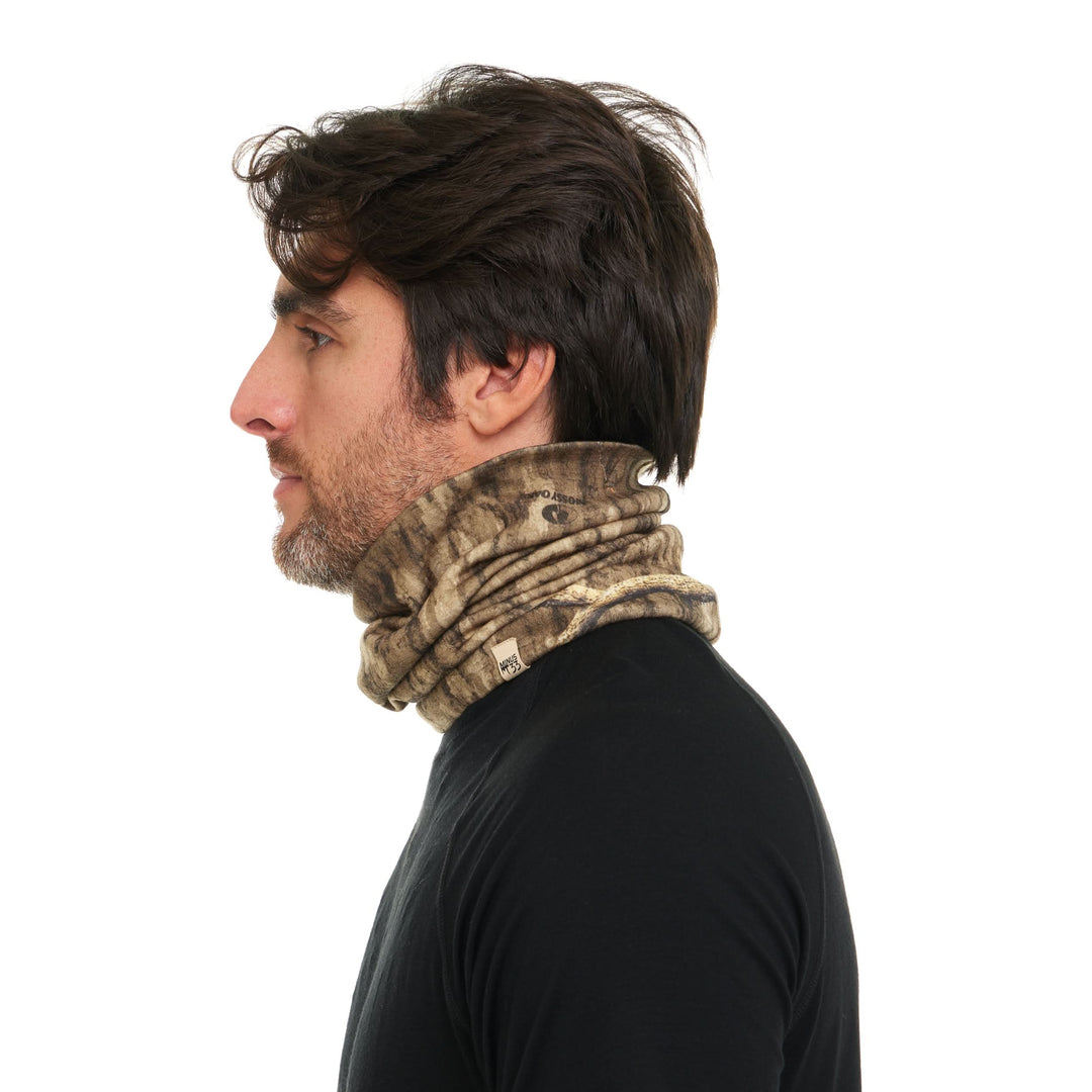 Camouflage merino wool neck gaiter worn lowered around the neck, left-side profile 