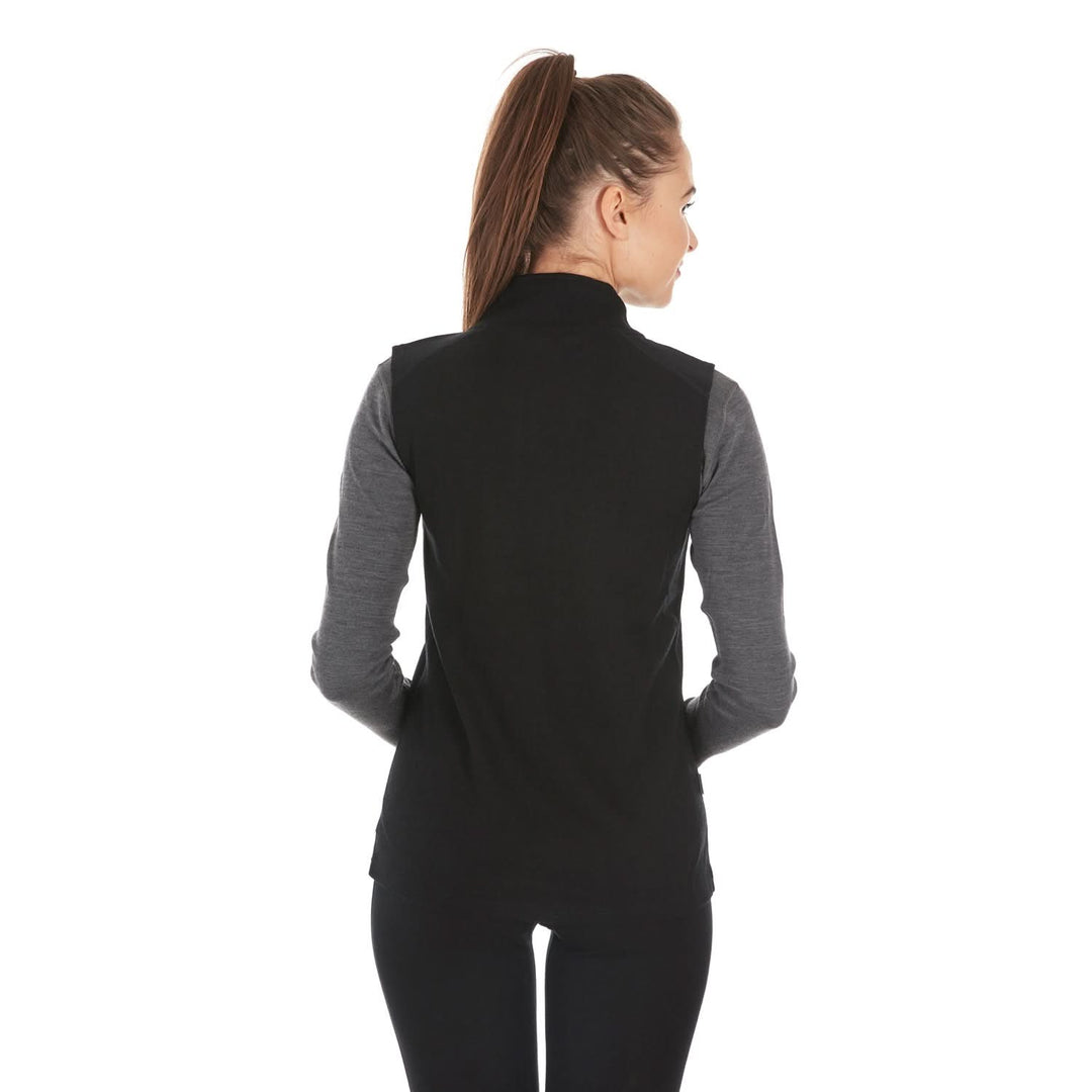 A woman models a hundred percent merino wool heavyweight full zip vest. This outer layer features a two and a half inch mock neck collar and two zippered pockets., back view 
