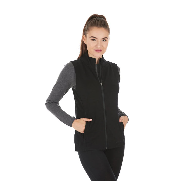 A woman models a hundred percent merino wool heavyweight full zip vest. This outer layer features a two and a half inch mock neck collar and two zippered pockets., front three-quarter view 