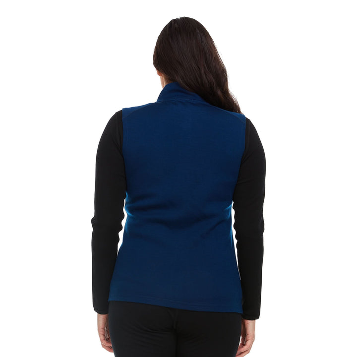 A woman models a hundred percent merino wool heavyweight full zip vest. This outer layer features a two and a half inch mock neck collar and two zippered pockets. Back view. 
