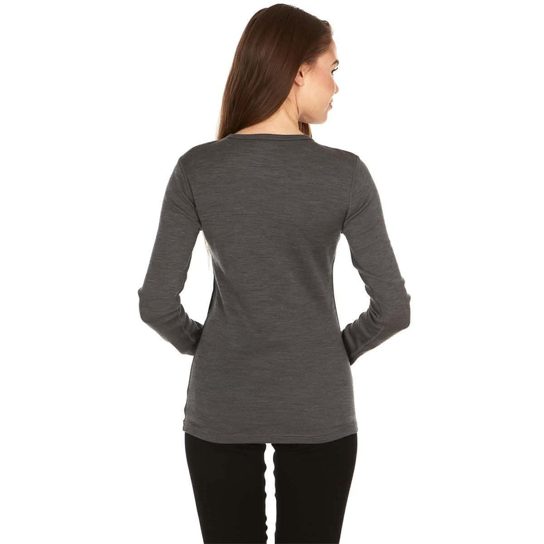 A woman models a soft, 100% merino wool, midweight base layer crew top. The women&