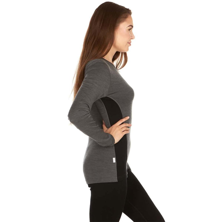 A woman models a soft, 100% merino wool, midweight base layer crew top. The women&