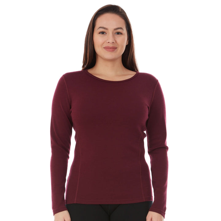 A woman models a soft, 100% merino wool, midweight base layer crew top. The women&