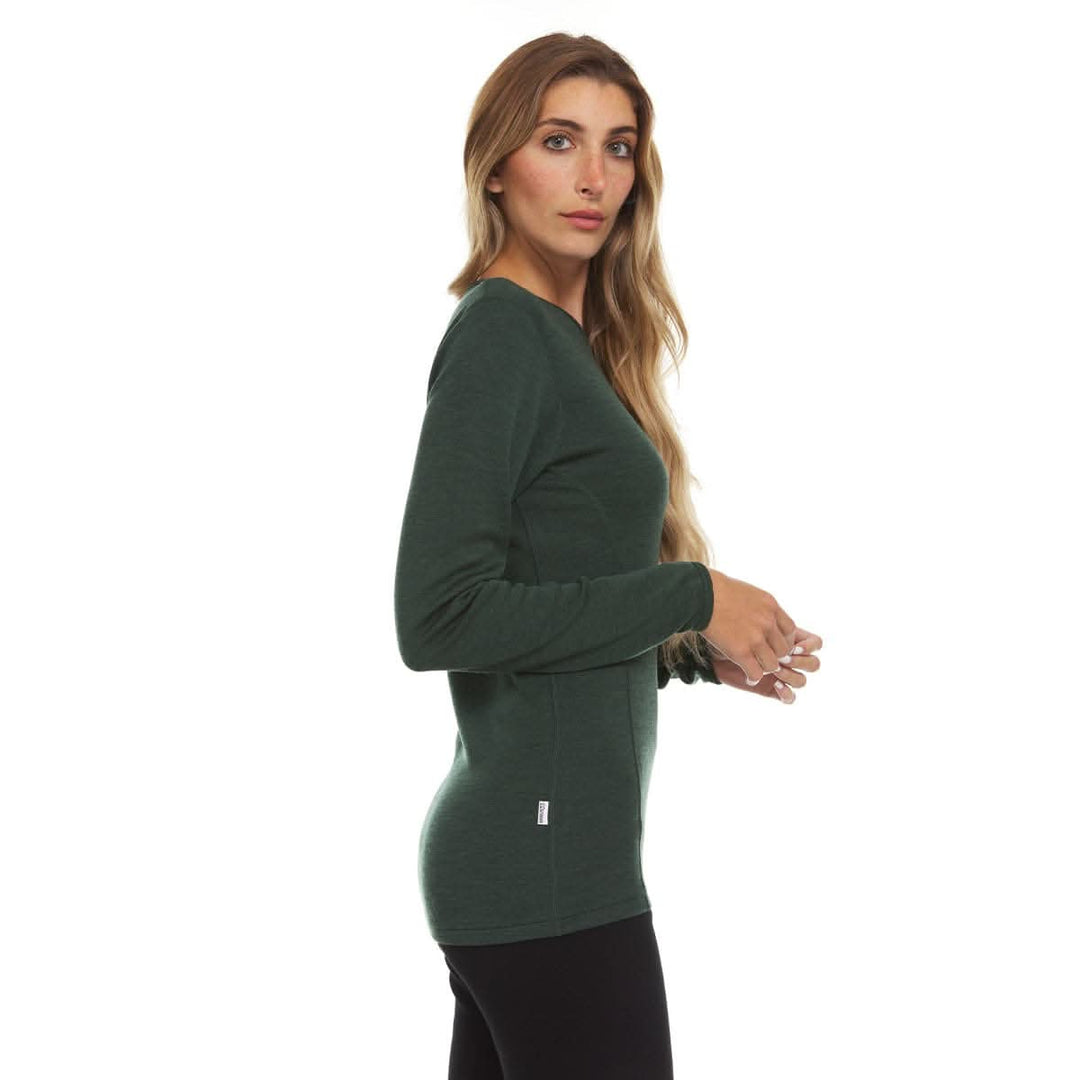 A woman models a soft, 100% merino wool, midweight base layer crew top. The women&